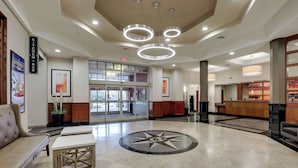 A hotel lobby with a reception desk, seating area, and a large window. - Drury Inn & Suites Charlotte Northlake (Charlotte)