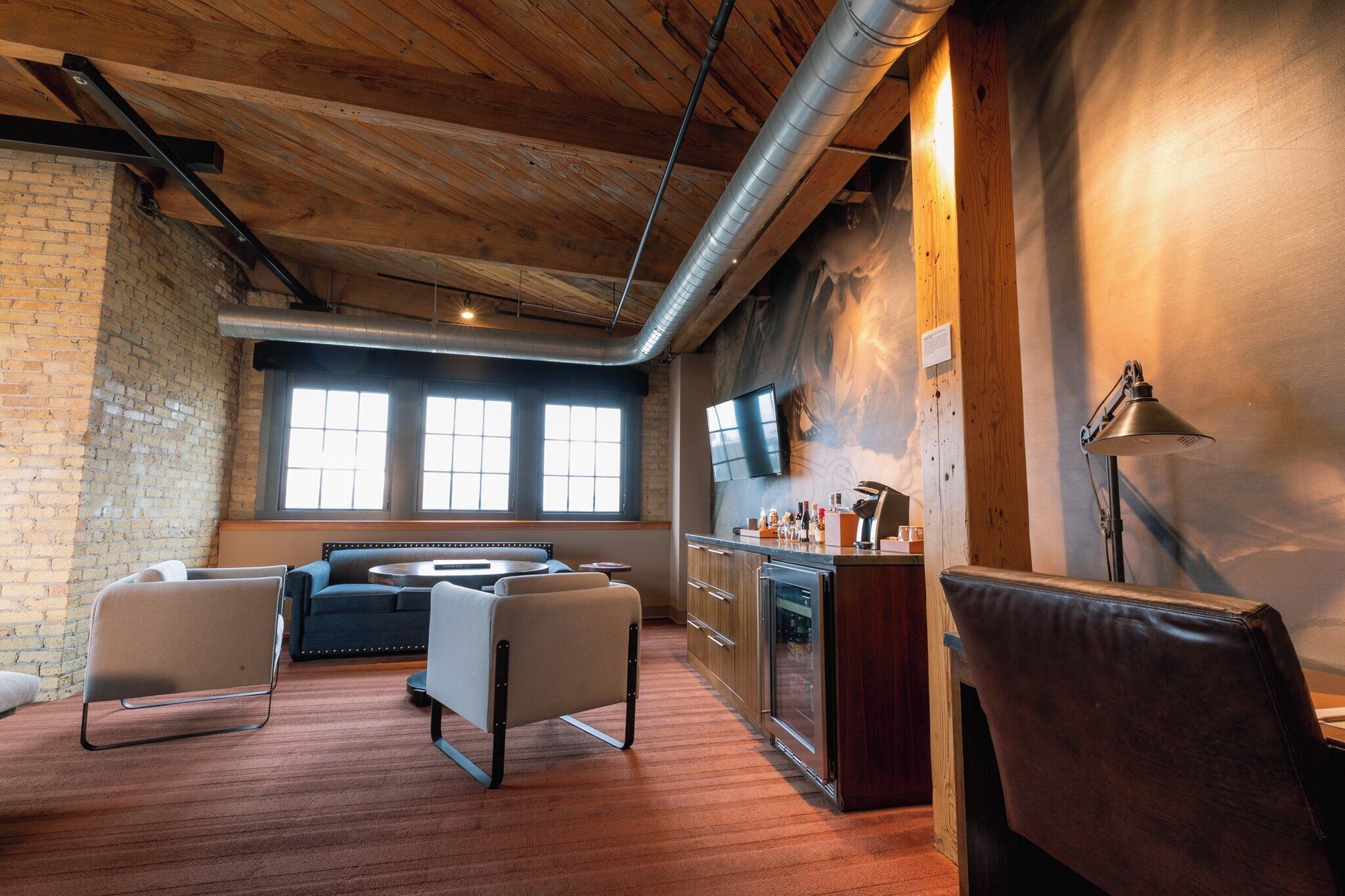 Een modern interieur met zichtbare bakstenen muren, een houten plafond en een keuken met een bar.