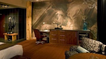 Relax in a stylish room with a comfortable bed, plush sofa, and artistic mural.