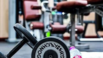 Un gimnasio con equipo de ejercicio, incluyendo una pesa, una cuerda para saltar y una botella de agua.