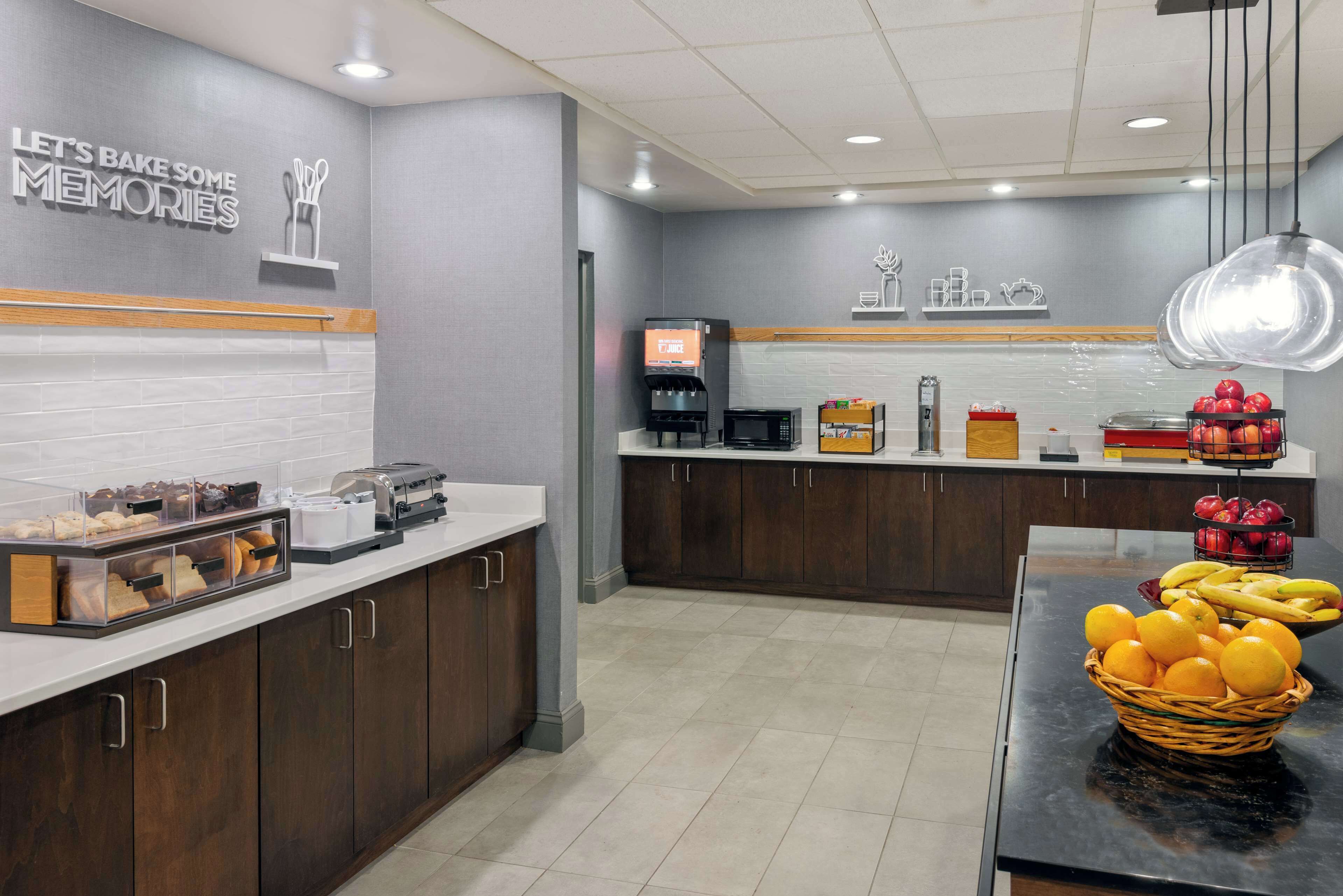 A modern kitchen area with a coffee machine, toaster, and various food items on the counter.