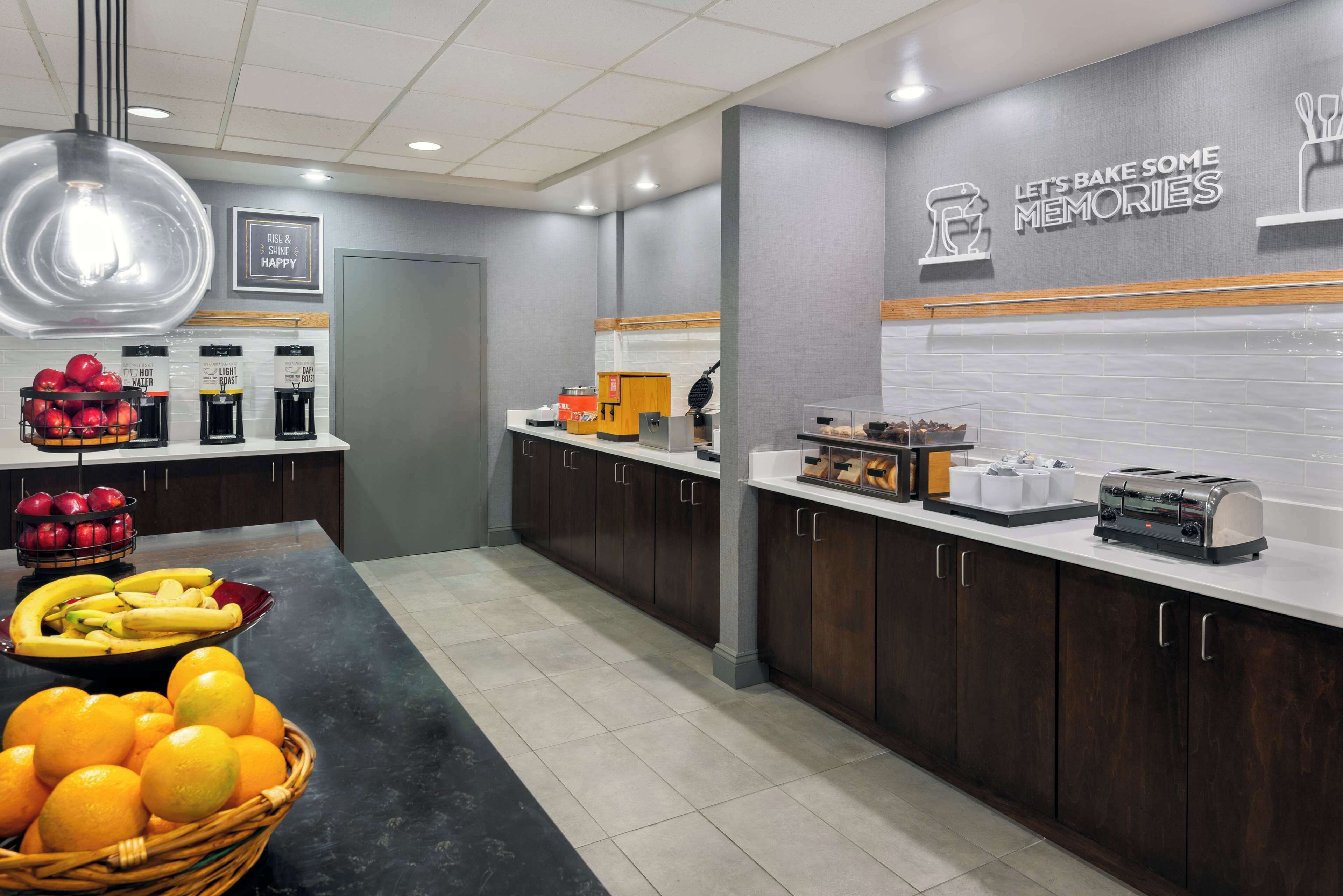 A modern kitchen with a central island, coffee station, and a sign that reads "Let's Bake Some Memories."