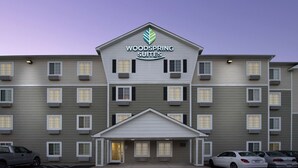 A multi-story hotel with a sign reading "Woodspring Suites." It features a symmetrical facade with evenly spaced windows and a central entrance. - WoodSpring Suites Lebanon (Lebanon)
