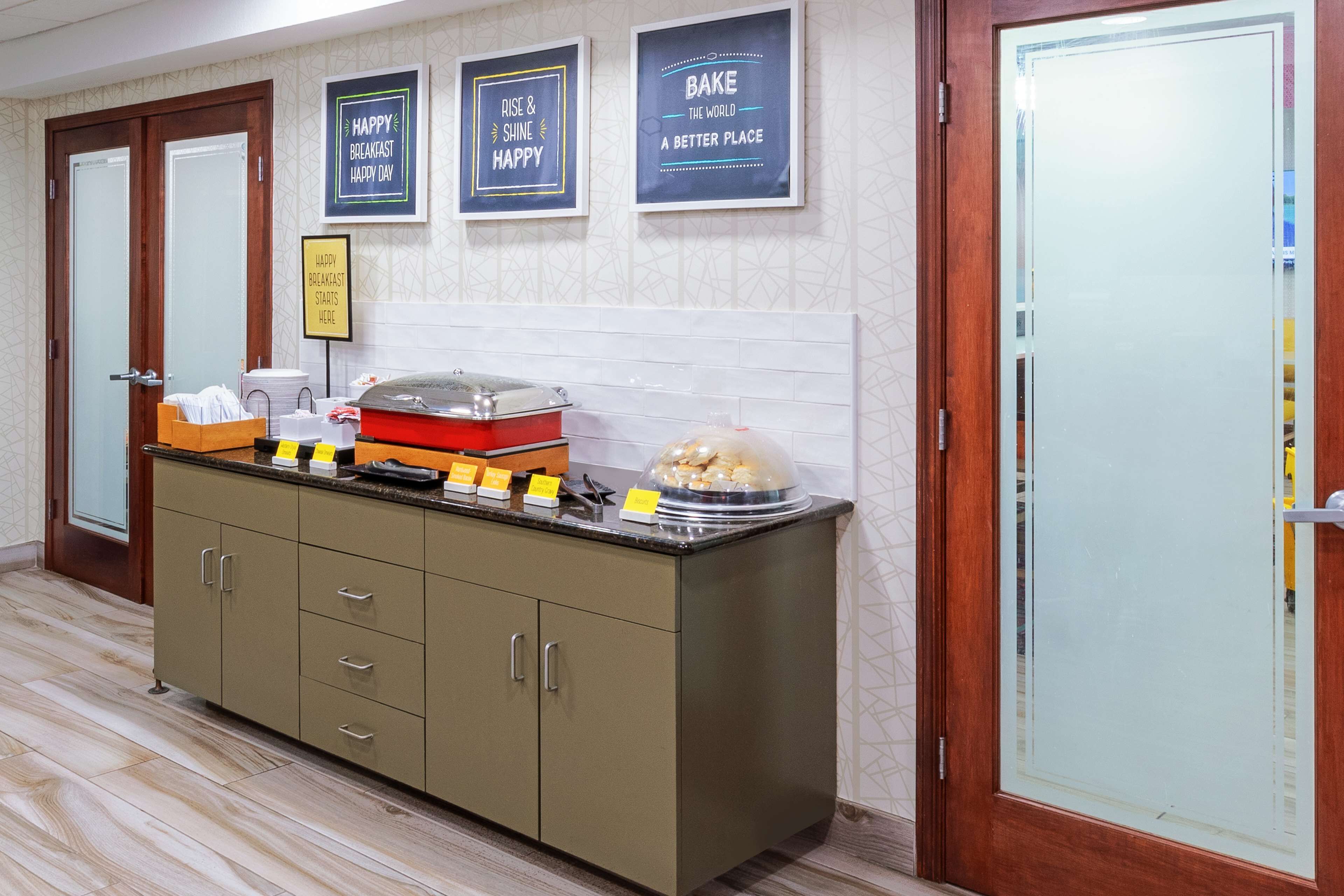 A breakfast bar with a variety of food items and a sign indicating the breakfast menu.