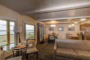 A hotel room with a dining area, kitchen, and large windows overlooking the beach. - Driftwood Shores Resort And Conference Center (Florence)