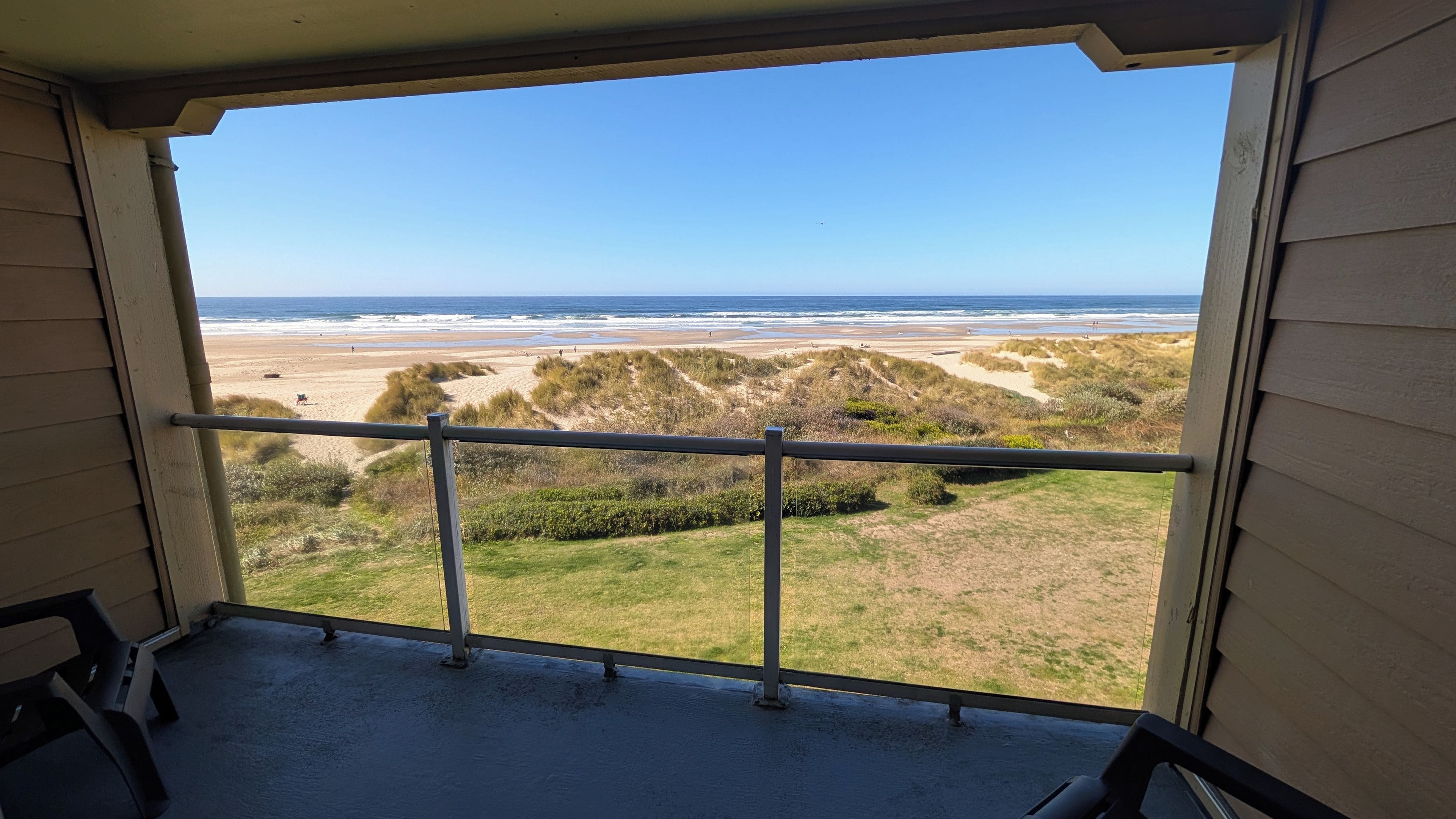 Ein Balkon mit Blick auf Strand und Meer.