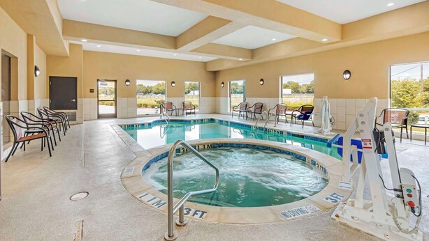 Uma área de piscina de hotel com hidromassagem, espreguiçadeiras e posto de salva-vidas.