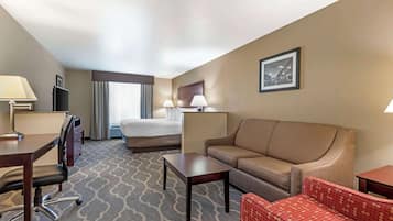 Una habitación de hotel con una cama, un sofá, un escritorio y una silla.