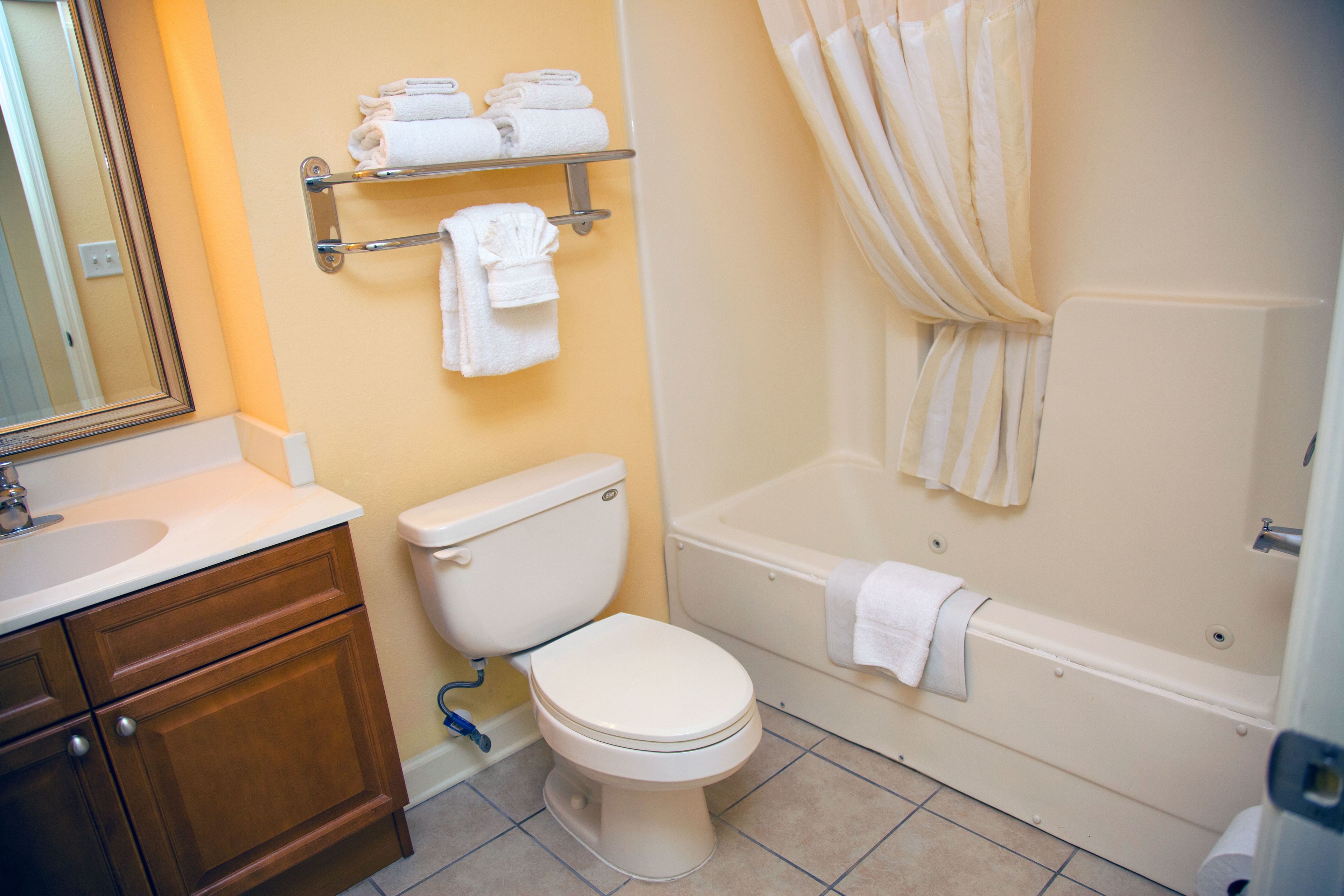 A bathroom with a toilet, a sink, a bathtub, and a shower curtain.