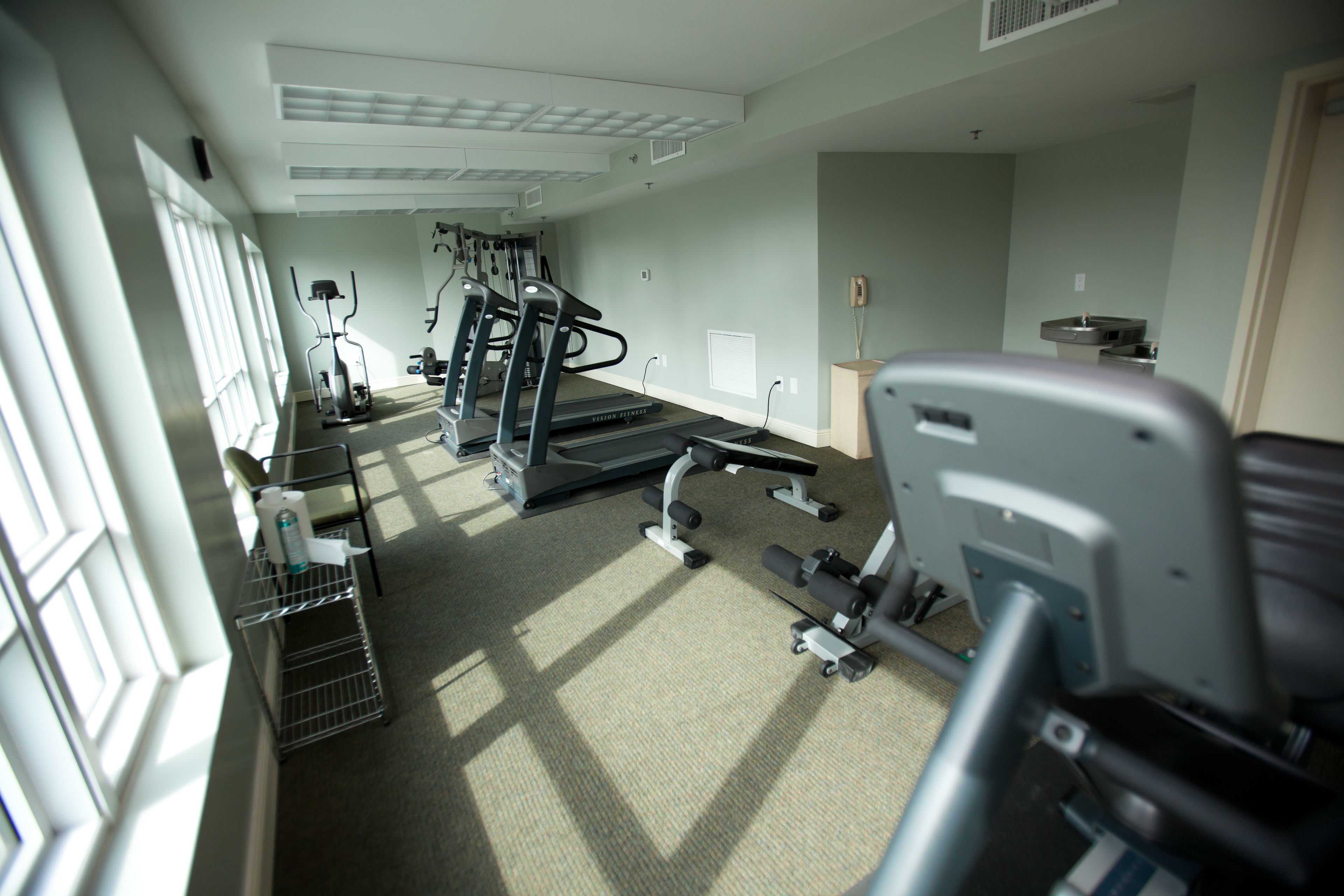 A gym with exercise equipment, a treadmill, and a weight bench.