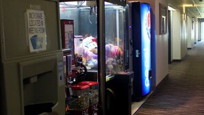 A hallway with vending machines and a microwave sign. - Eastwood Inn (Motley)