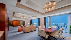 A spacious hotel room with a large conference table, comfortable seating, and a city view. - Crowne Plaza Beijing Sun Palace by IHG (Beijing)
