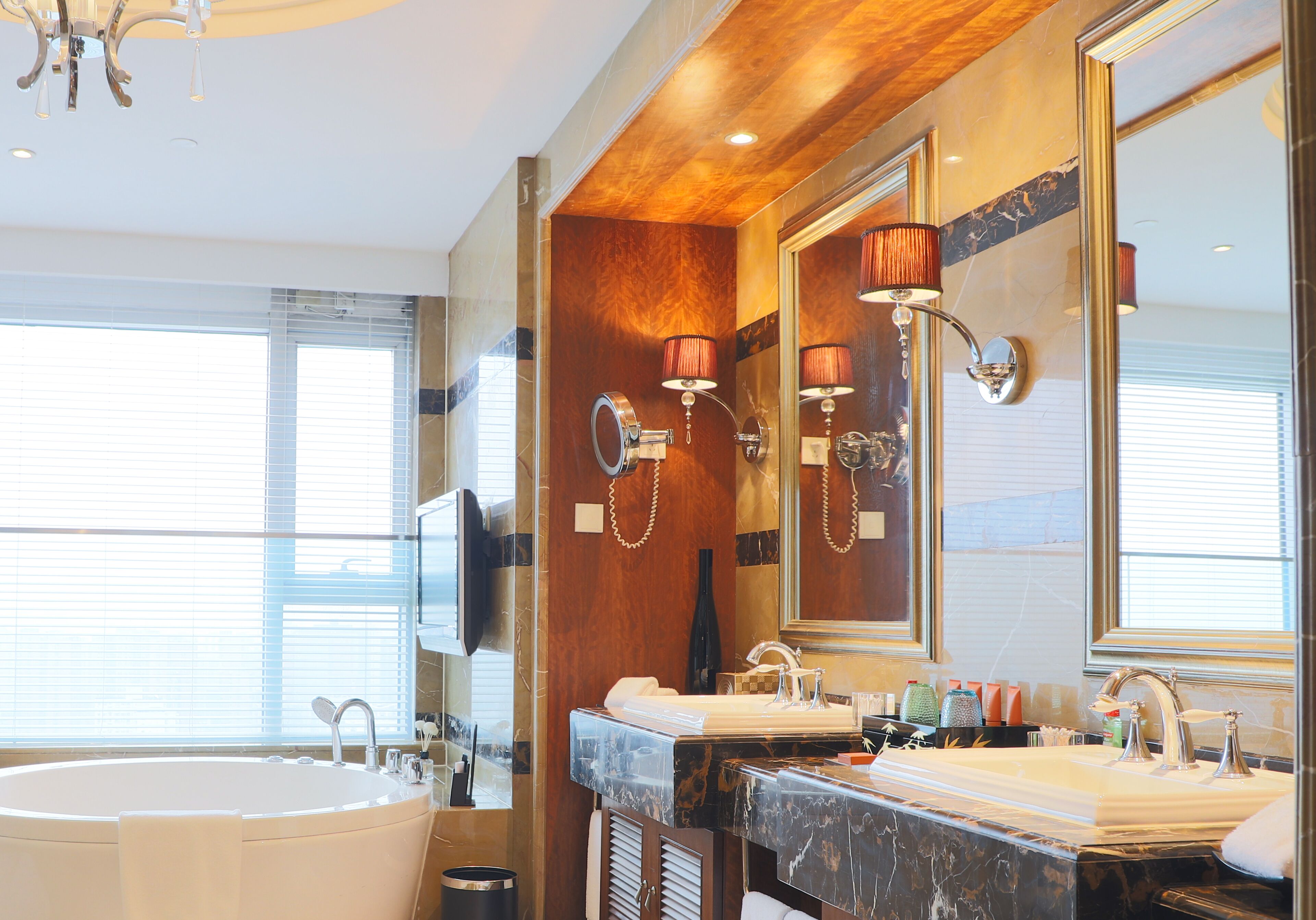 A modern bathroom with a freestanding bathtub, dual sinks, and a large mirror.