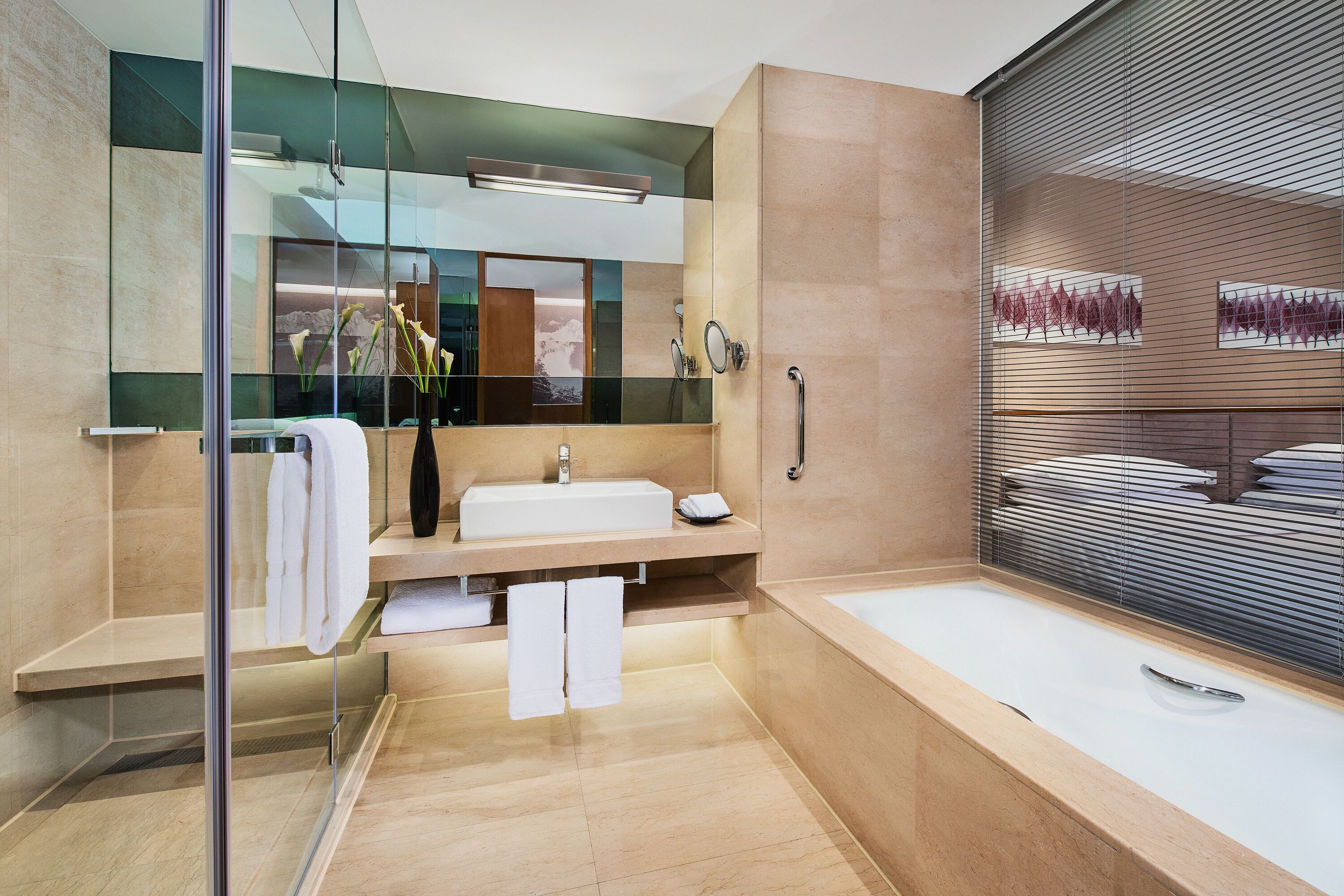 Un baño moderno con cabina de ducha de vidrio, un espejo grande y una bañera.