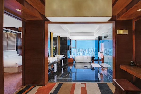 Een moderne badkamer met een badkuip, twee wasbakken en een grote spiegel.
