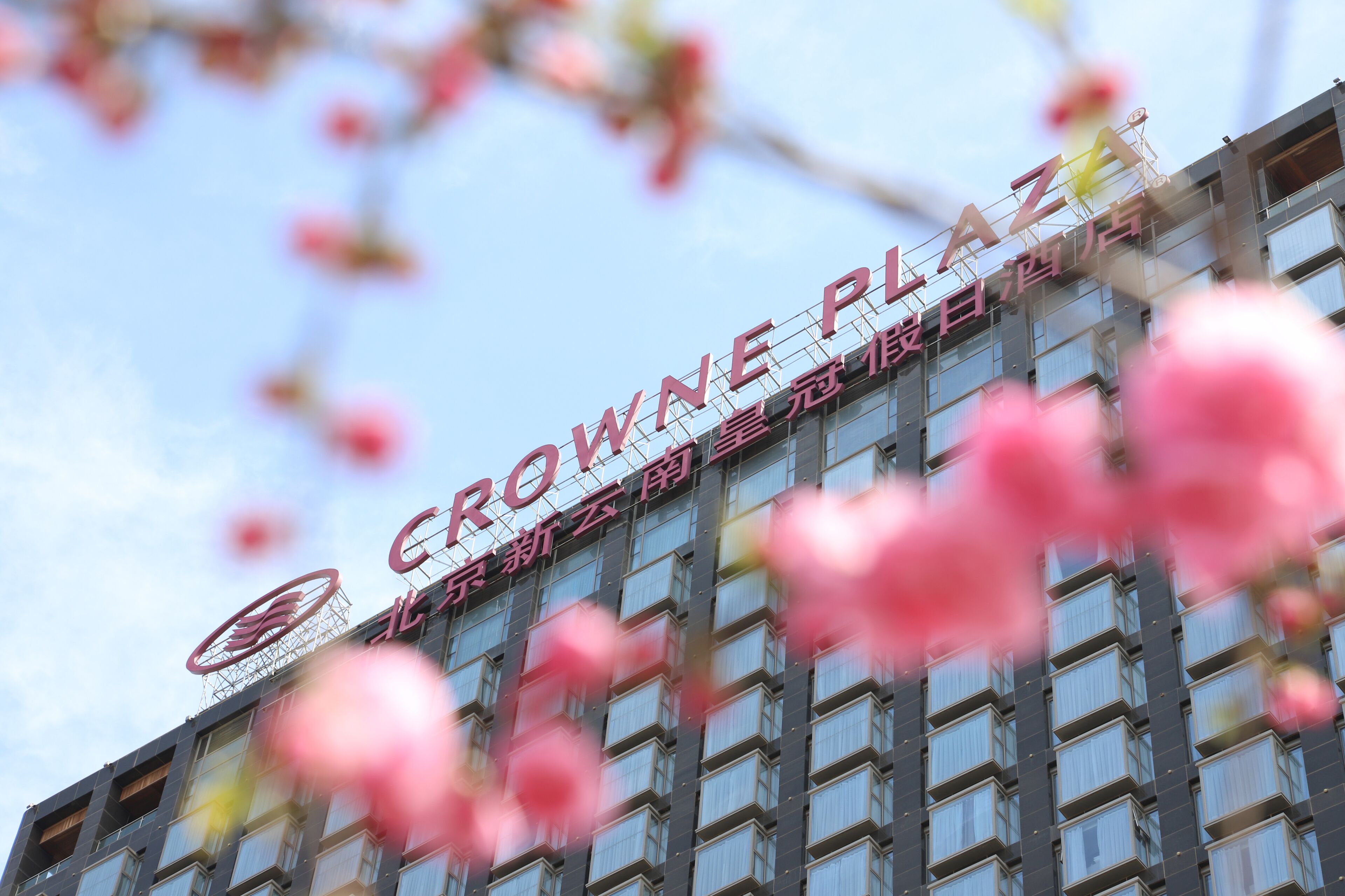 A building with the sign "CROWNE PLAZA" and a logo above it.
