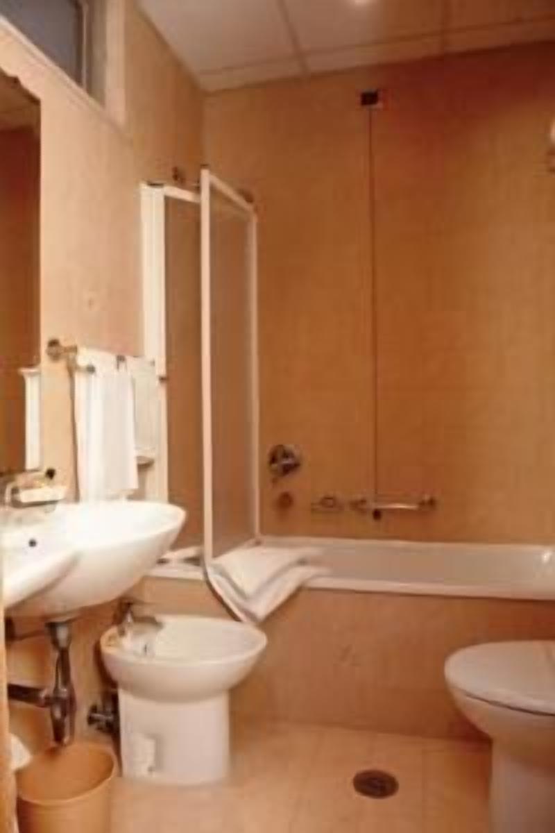 A bathroom with a bathtub, a toilet, and a bidet.