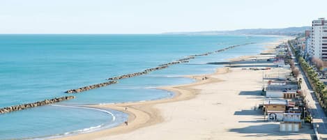 Privat strand, solstolar, parasoller och strandbarer