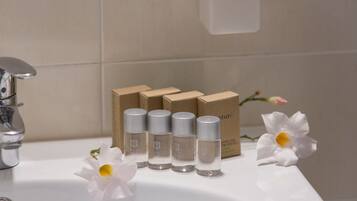 A bathroom sink with four bottles of lotion and a box labeled "nature" in the background.
