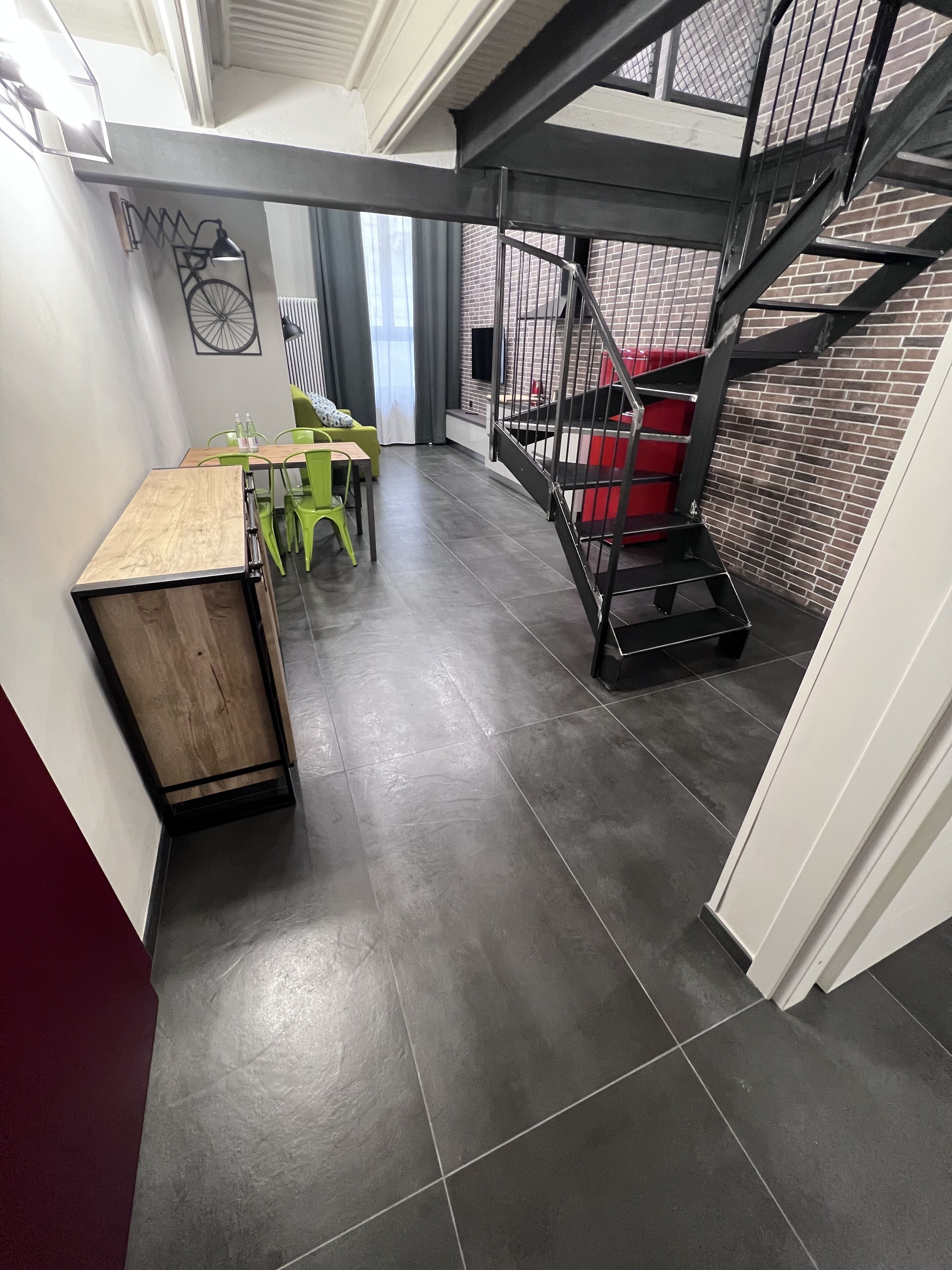 Et moderne interiør med et spiseområde, en trappe og et rødt opbevaringsskab.