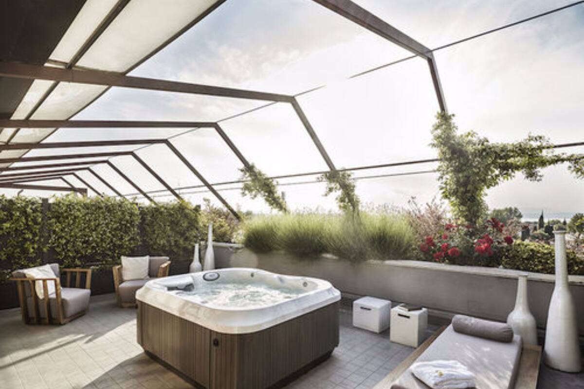 A rooftop terrace with a hot tub, seating area, and a view of the city.