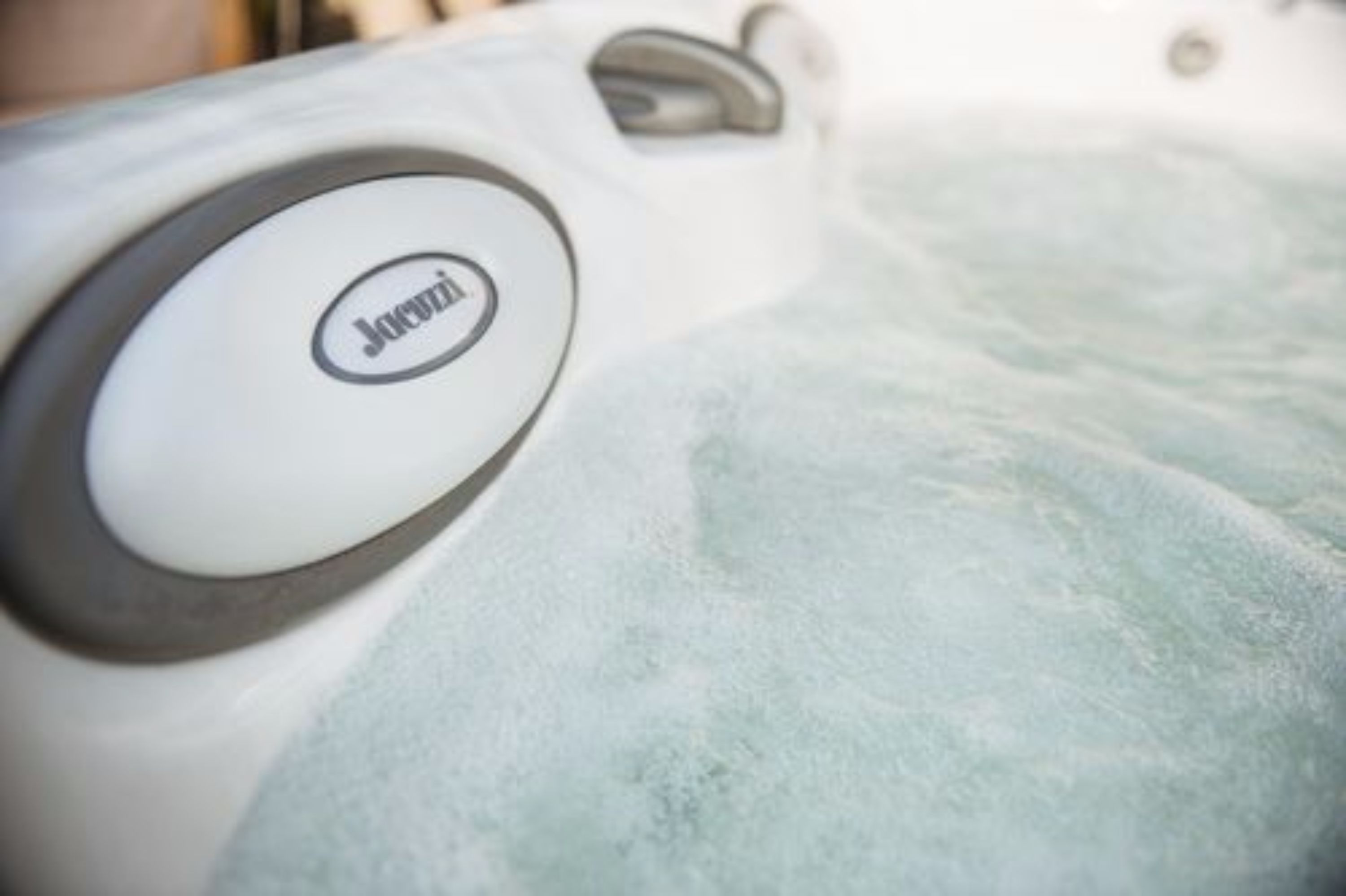 Gros plan du logo de la marque Jacuzzi sur une surface blanche.