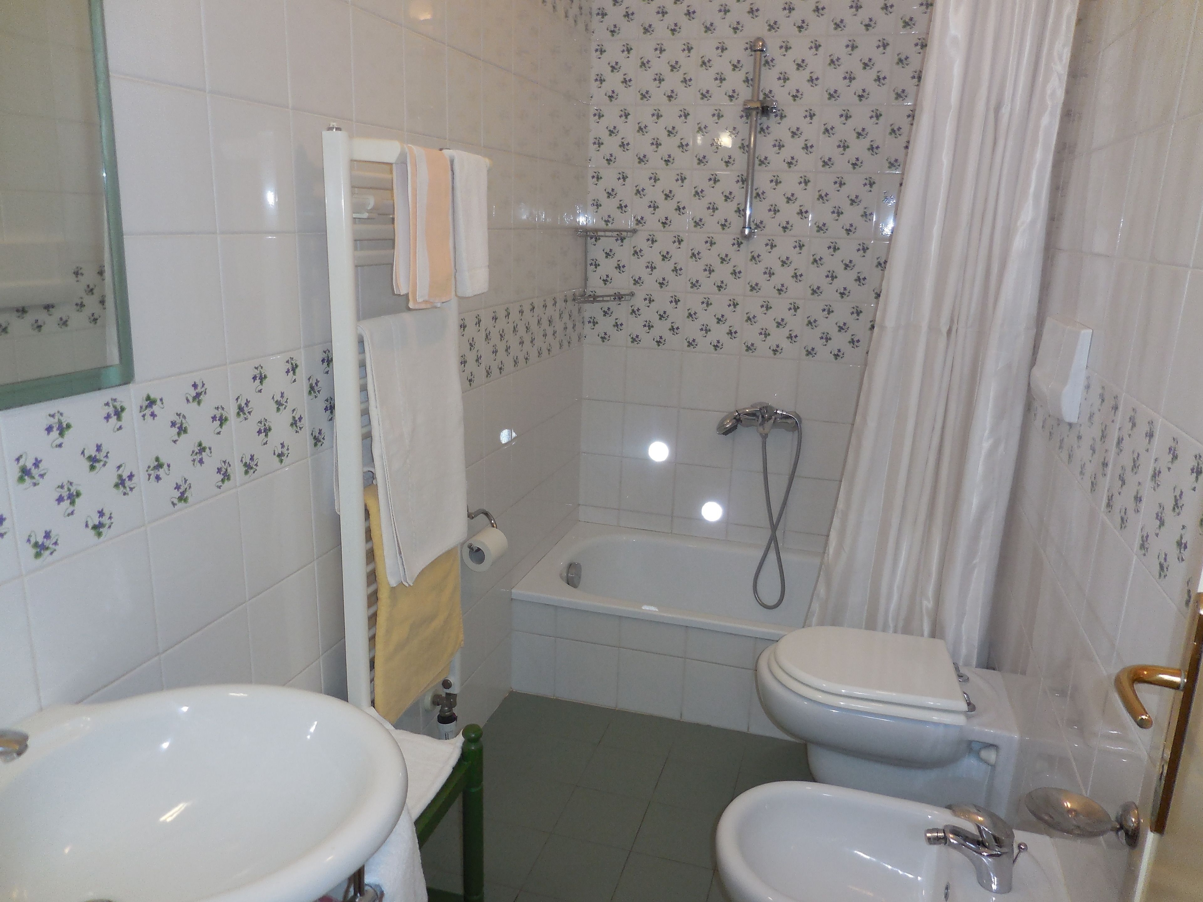 Casa de banho com duas pias, sanita, banheira e chuveiro.