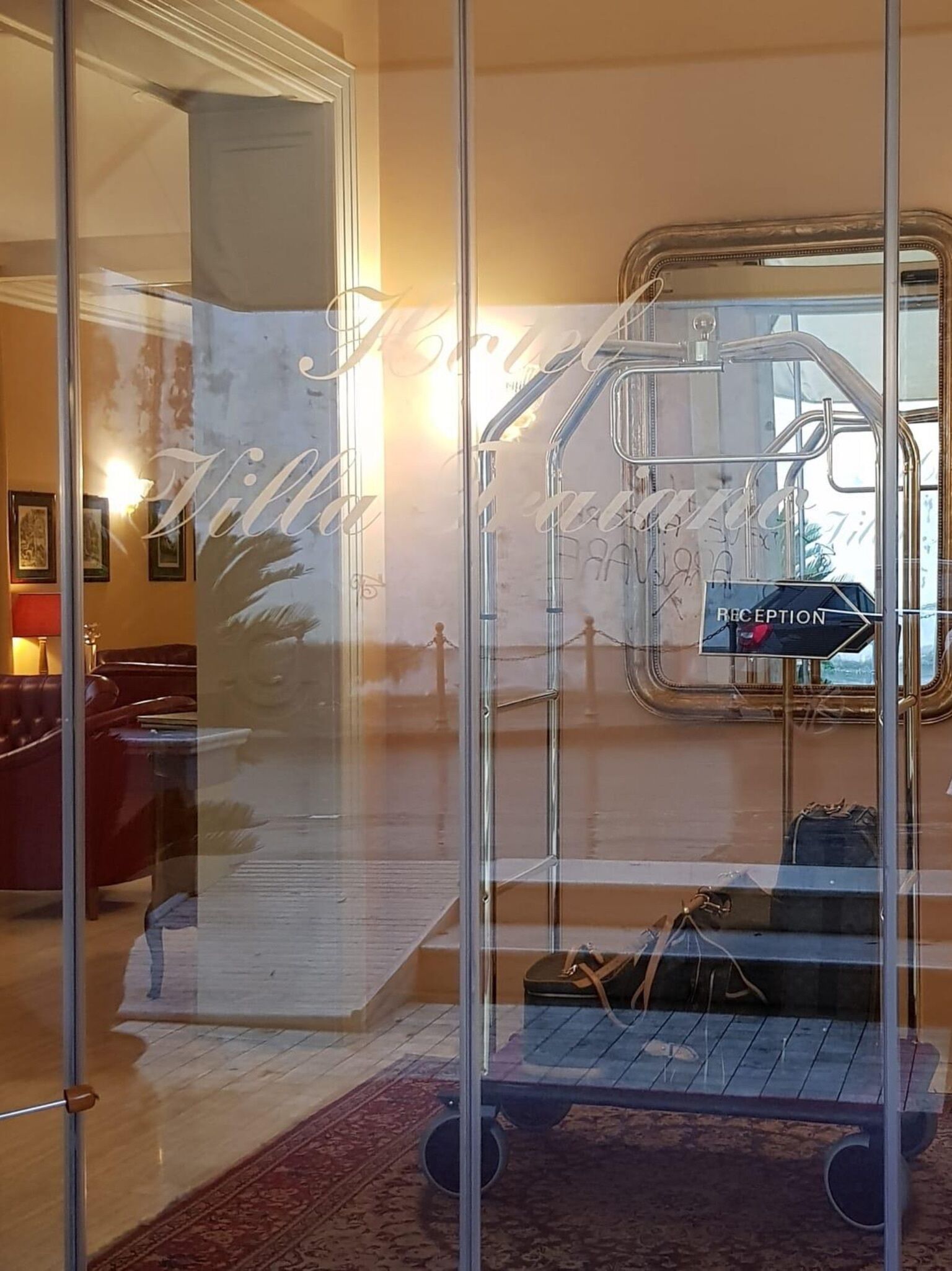 Zona de recepción con separador de vidrio, mostrador de recepción y un cartel que indica la recepción.