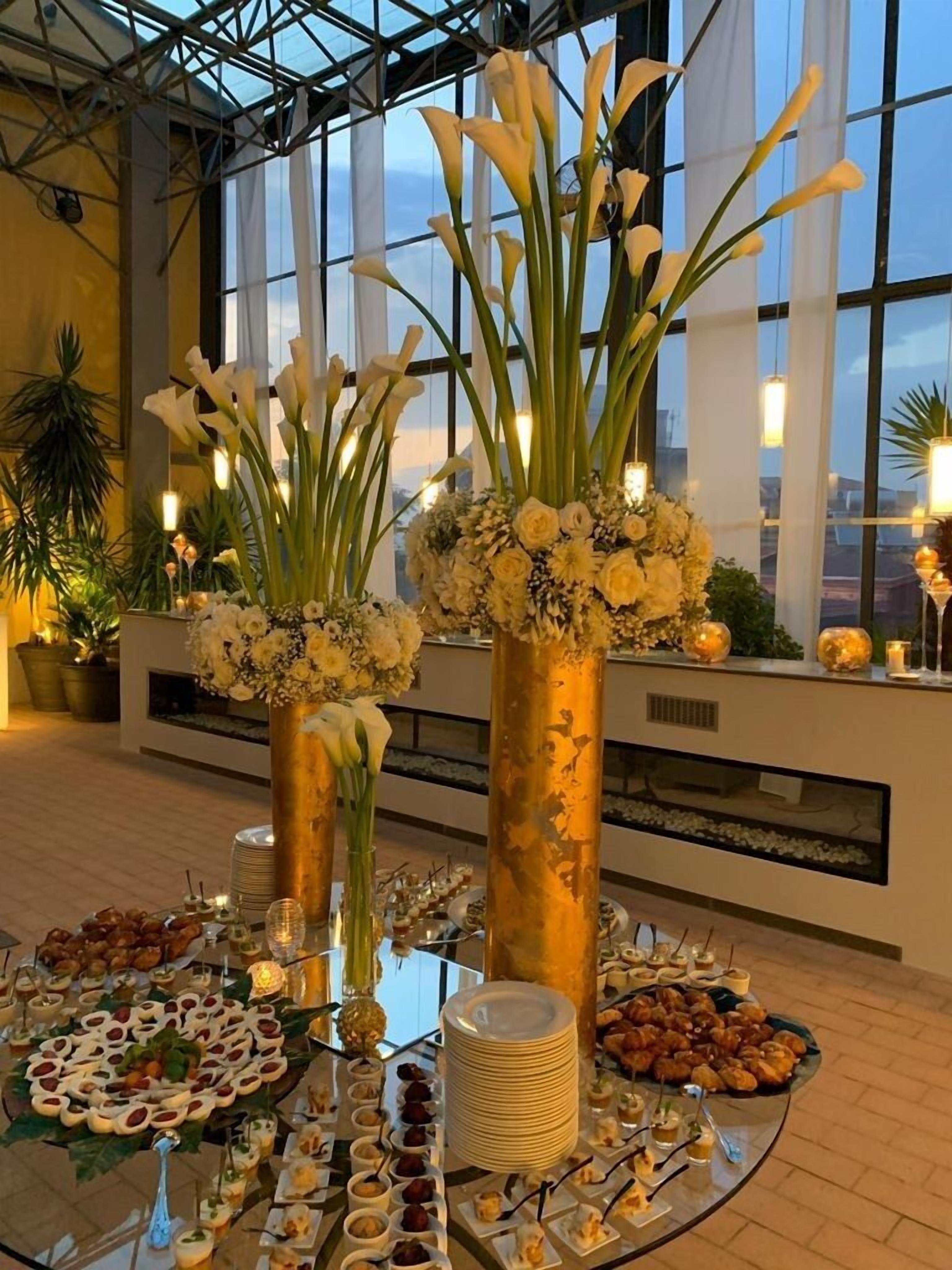 A buffet setup with floral centerpieces and a variety of food items.