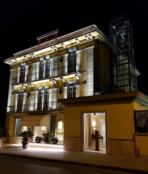 Vista frontal de la propiedad por la tarde o noche