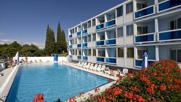 Una piscina al aire libre de temporada, sombrillas