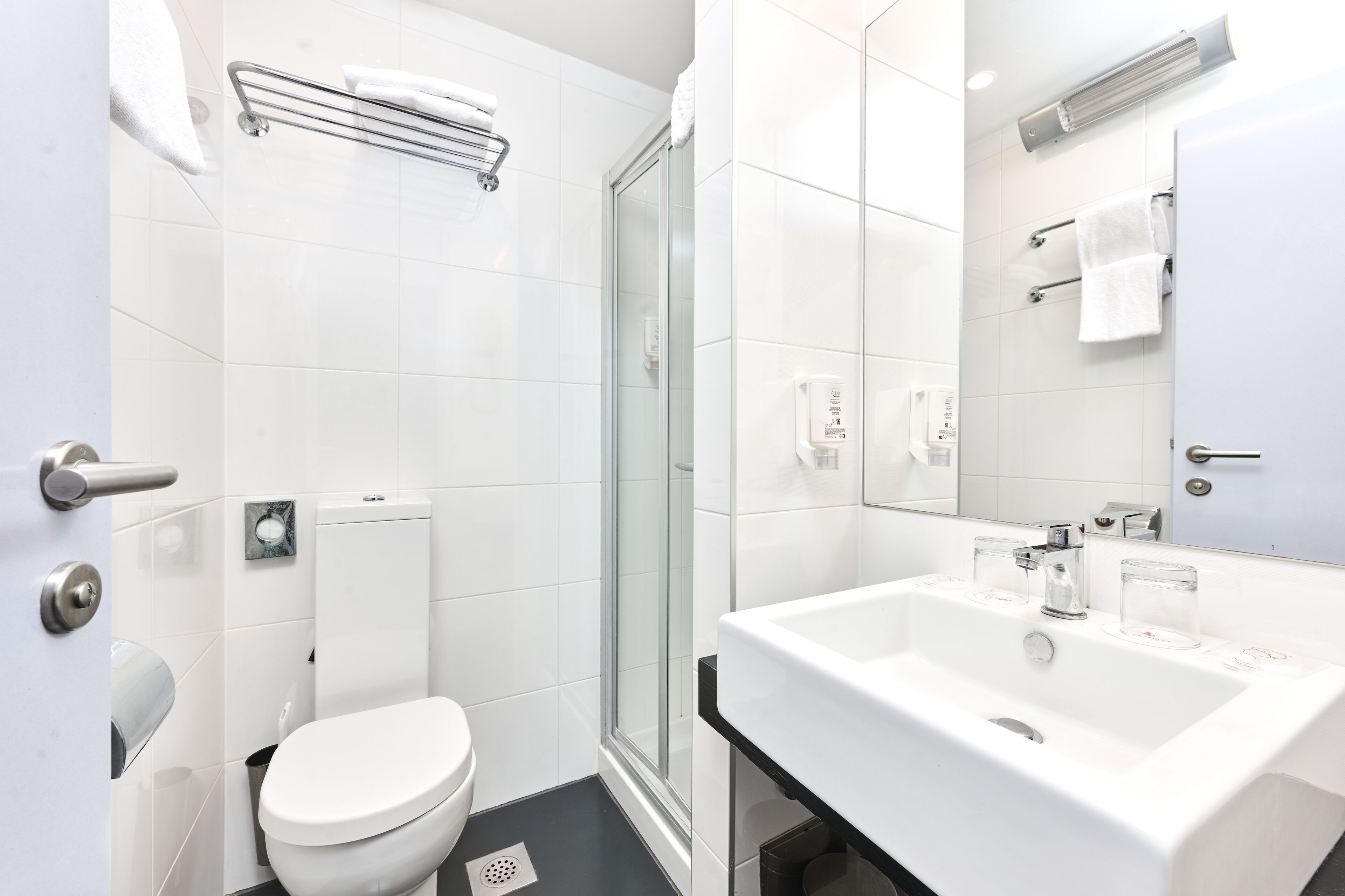 A modern bathroom with a toilet, shower, and sink.