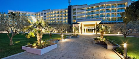 Ein modernes Hotel mit Innenhof, mehreren Etagen und einem gut beleuchteten Eingang.