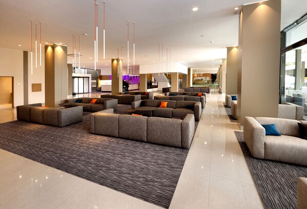 A spacious lobby with multiple seating areas, a reception desk, and a staircase leading to upper floors. - Hotel Materada Plava Laguna (Porec)