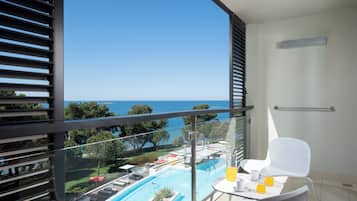 Un balcón con vista a una piscina y al mar.