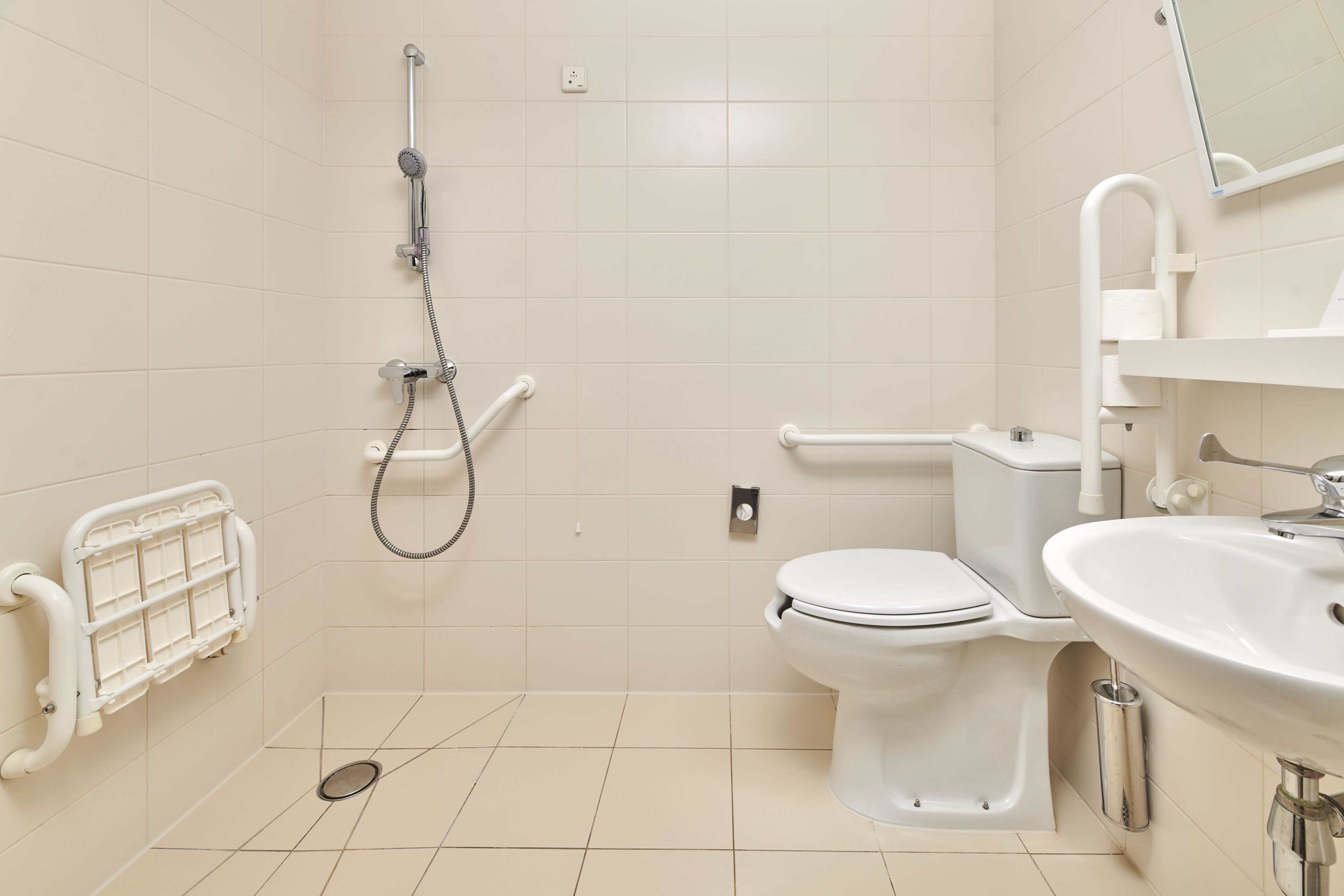 A modern bathroom with a toilet, sink, and shower.