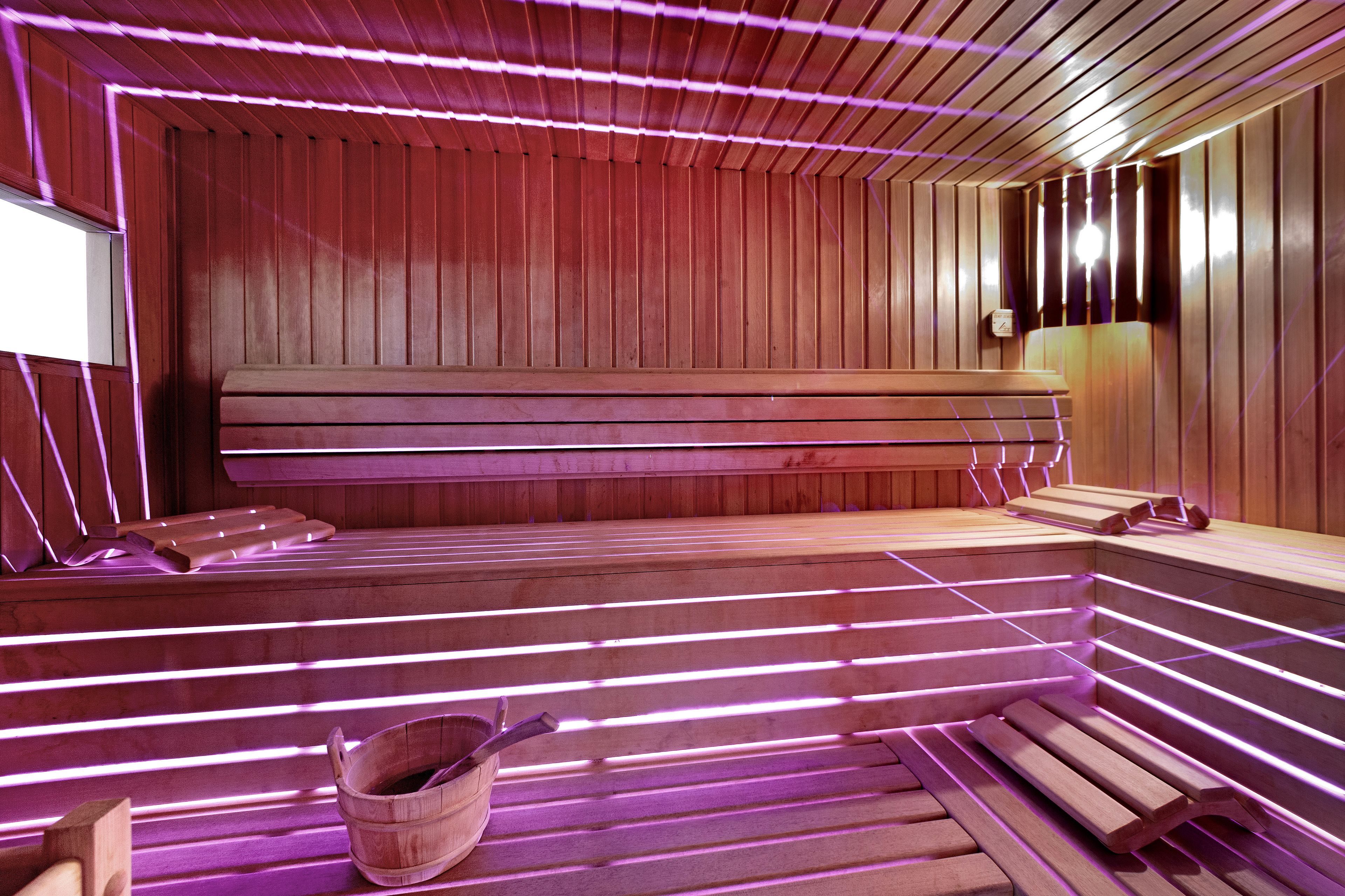 Una sauna con bancos de madera y un balde.