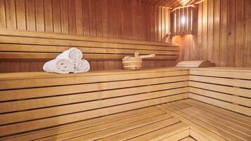 A wooden sauna with benches, towels, and a wooden bucket with a brush.