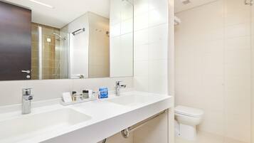 Un baño moderno con dos lavamanos, un espejo y un inodoro.