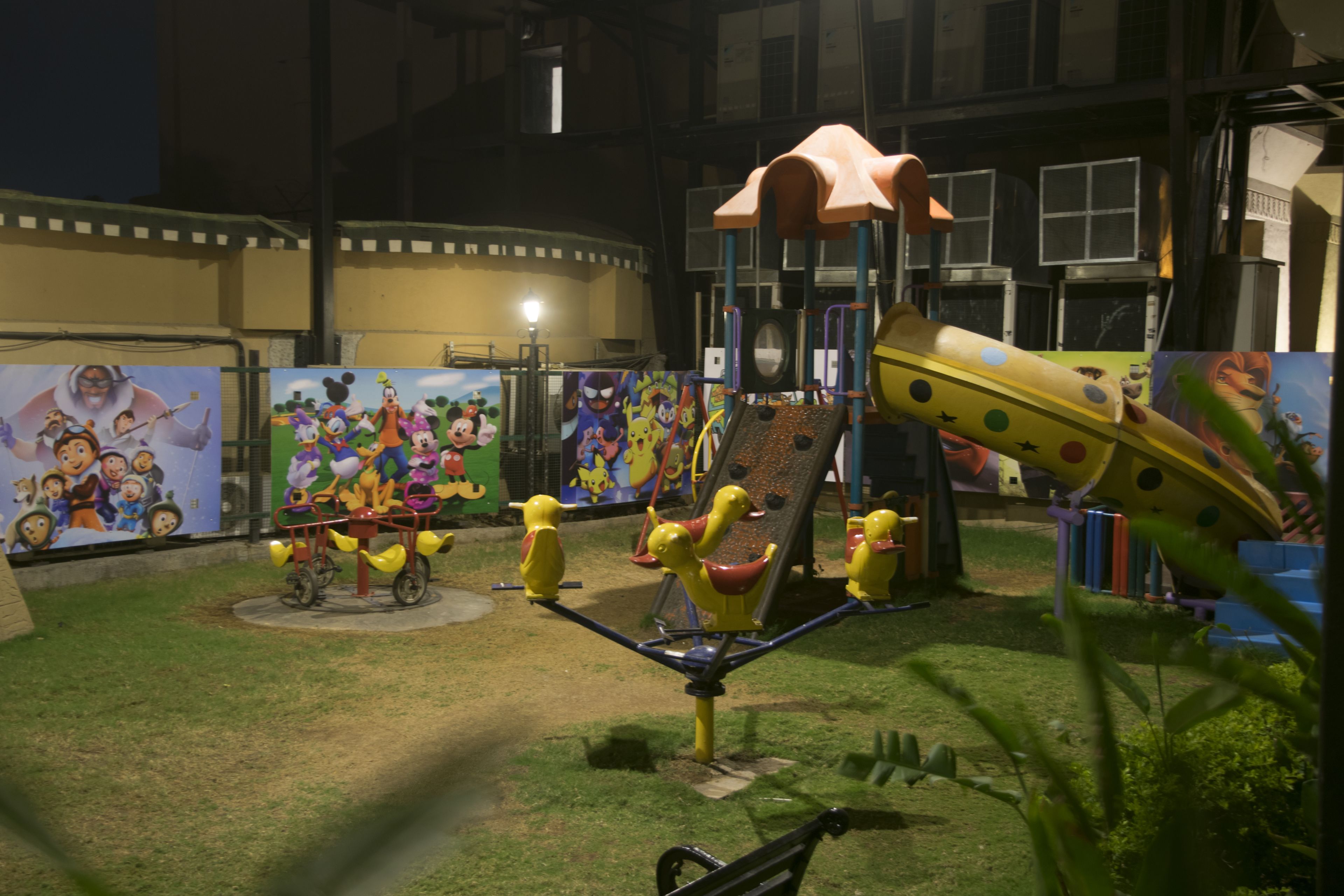 Ein Spielplatz mit Rutsche, Schaukeln und einer Kletterkonstruktion.