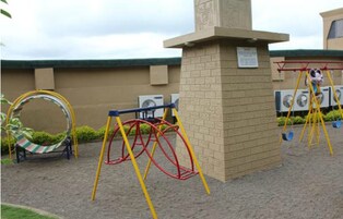 Un'area giochi con altalene e una struttura di arrampicata circolare.