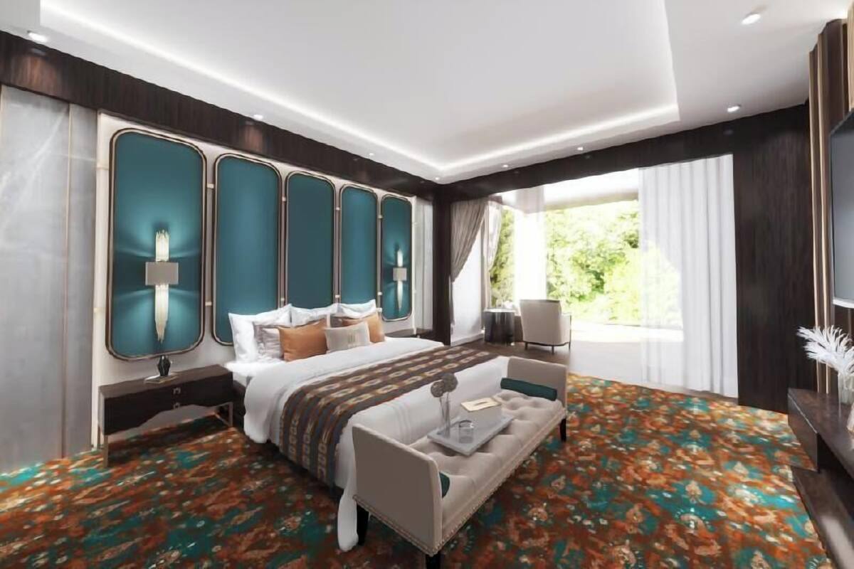 Habitación de hotel moderna con una cama grande, un sofá, un escritorio y vistas a zonas verdes.