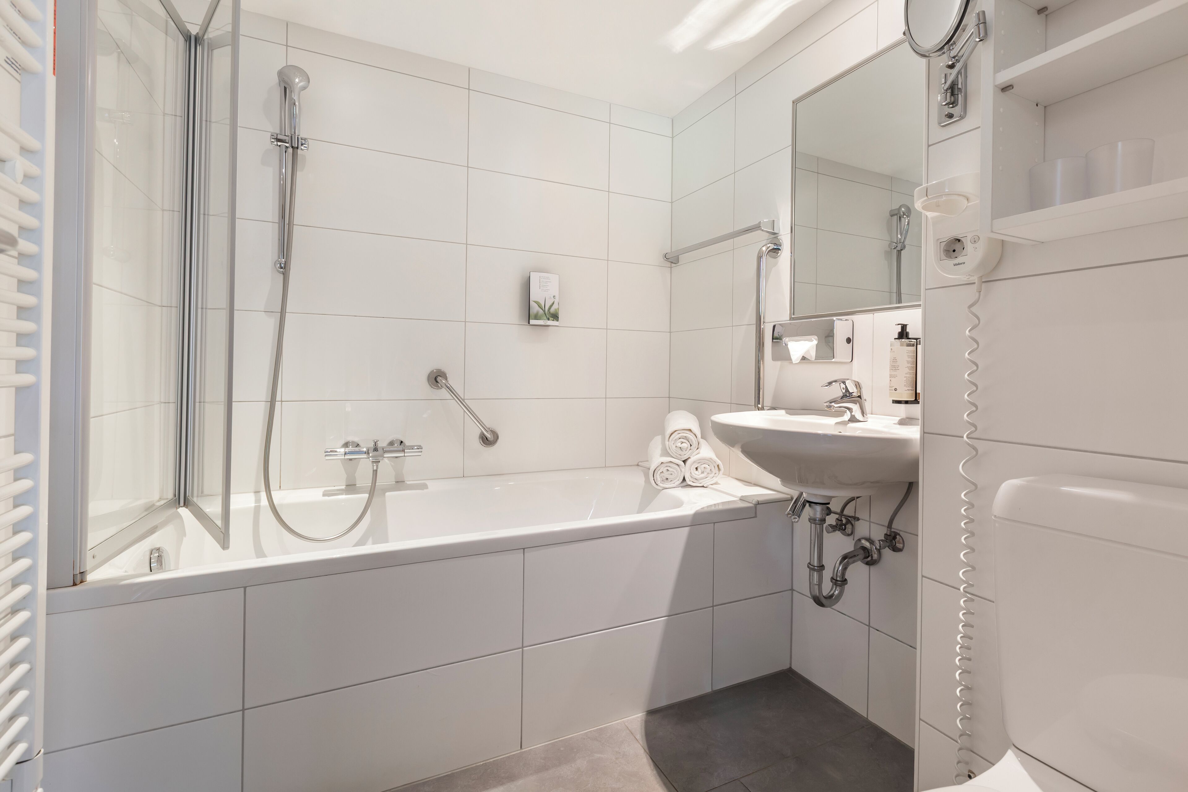 Ein modernes Badezimmer mit Badewanne, Dusche und Waschbecken.