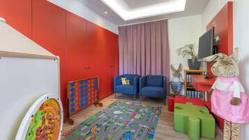A child's playroom with a colorful mat, toys, and a plush toy.