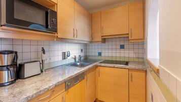 A kitchen with wooden cabinets, a microwave, a toaster, and a coffee maker.
