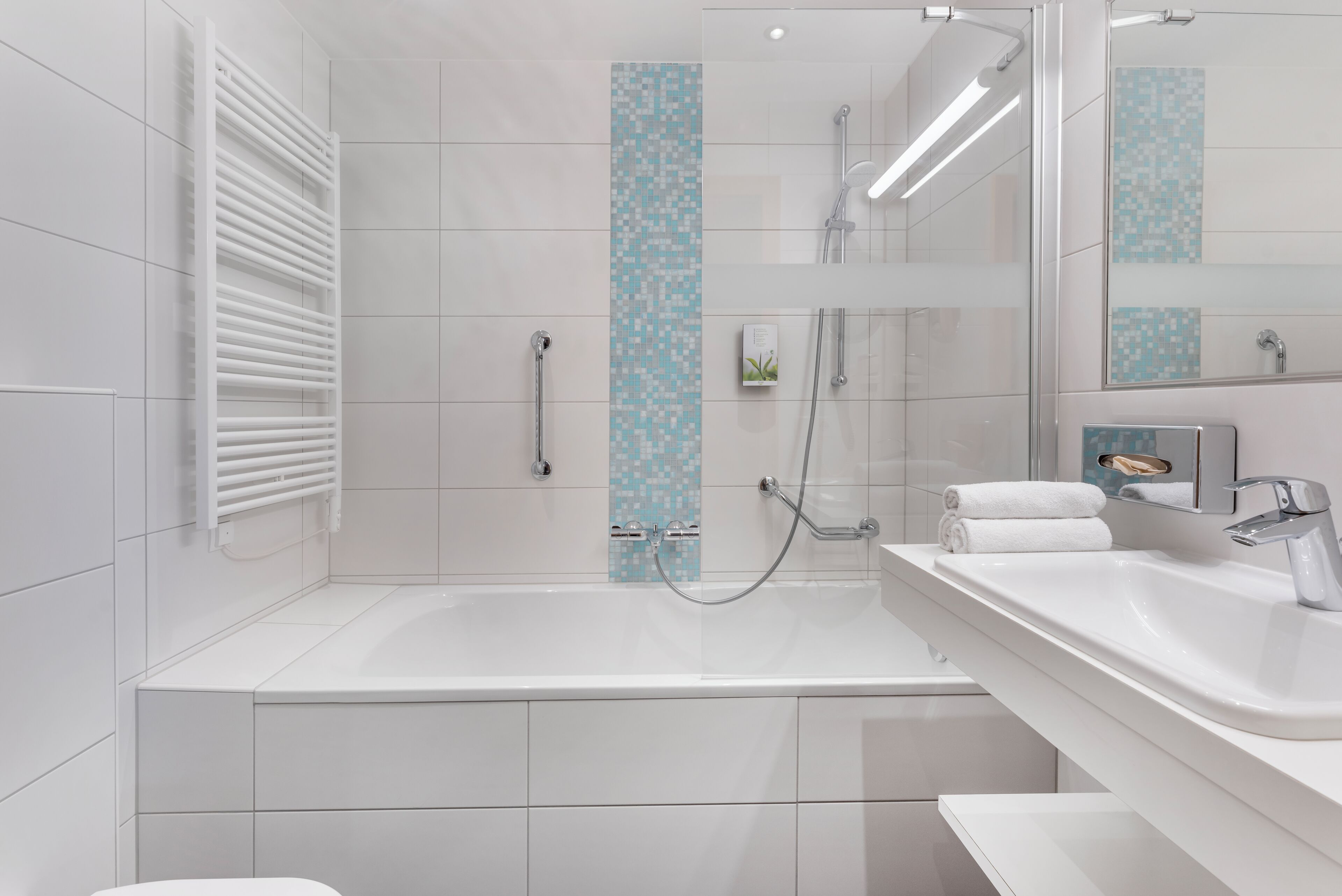 A modern bathroom with a bathtub, a shower, and a sink.