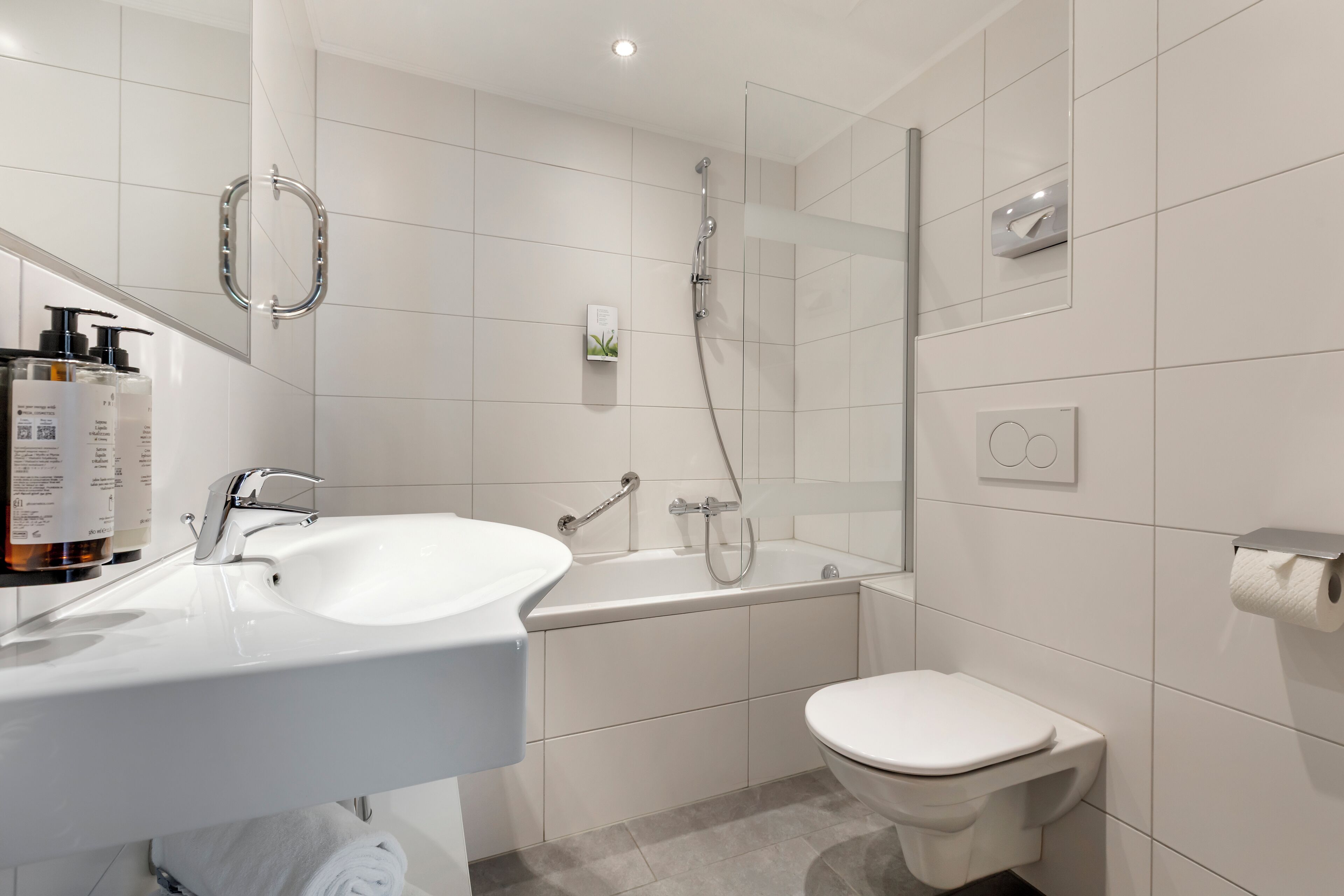 Un baño moderno con lavamanos blanco, bañera y retrete.