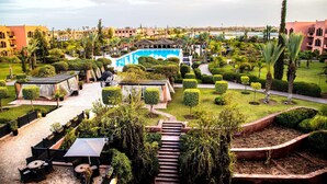 Un resort con piscina, zona de estar al aire libre y jardines cuidados.