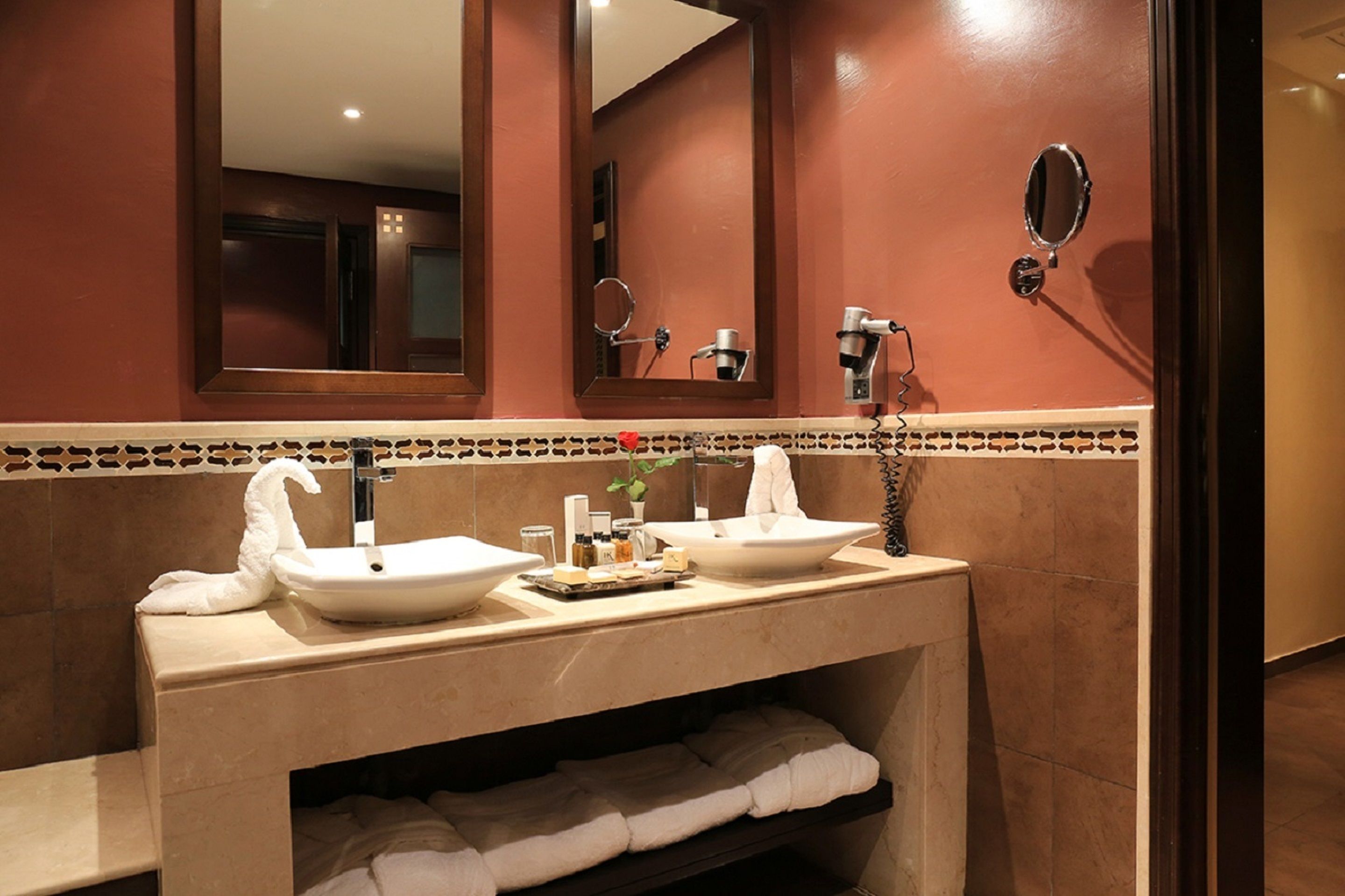 A bathroom with two sinks, a mirror, and a towel rack.