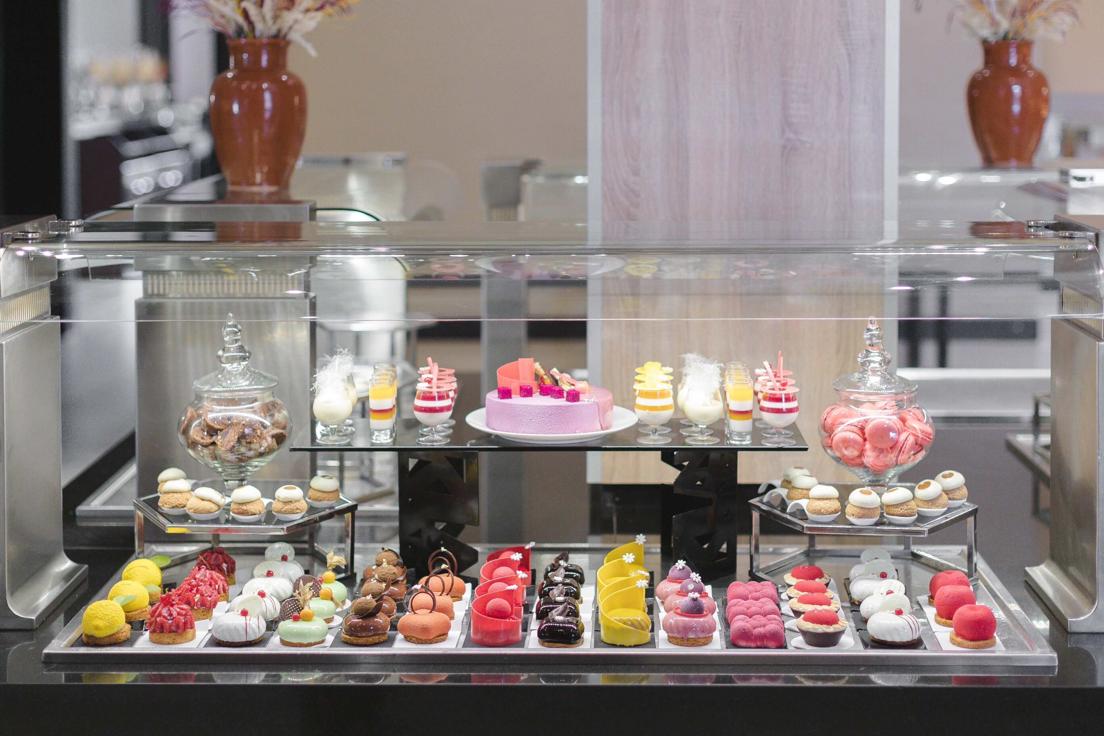 Una vitrina con diversos pasteles y postres.
